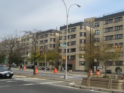 Pre-war apartment buildings of tan and red brick lining the Grand Concourse in the Bronx