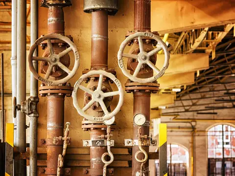 Old pipes and valve wheels in a building's plumbing