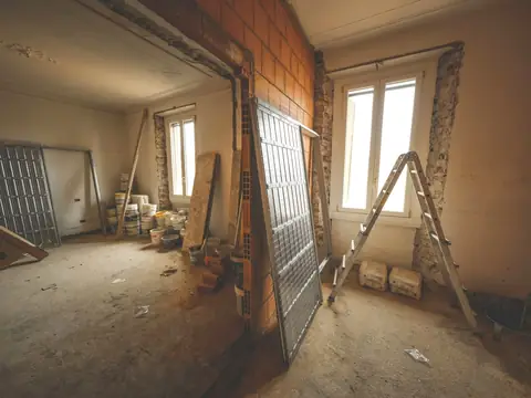A room under repair, the walls opened up and a ladder standing by the window